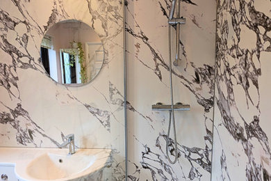 Photo of a medium sized modern family bathroom in Other with white cabinets, a walk-in shower, a one-piece toilet, an integrated sink, solid surface worktops, brown floors, an open shower, white worktops, a single sink, a built in vanity unit and panelled walls.
