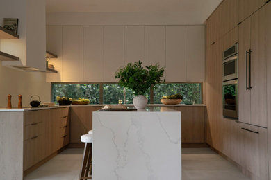 Large trendy u-shaped ceramic tile and gray floor eat-in kitchen photo in Miami with a single-bowl sink, flat-panel cabinets, light wood cabinets, quartz countertops, white backsplash, quartz backsplash, stainless steel appliances, an island and white countertops