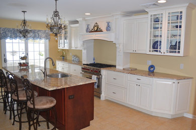 Example of a large classic galley beige floor open concept kitchen design in New York with an undermount sink, raised-panel cabinets, white cabinets, granite countertops, stainless steel appliances and an island