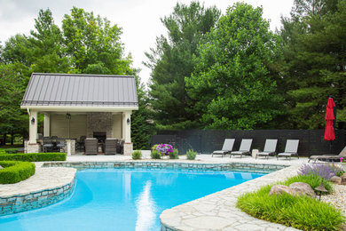 Imagen de piscina natural clásica de tamaño medio en patio trasero con losas de hormigón