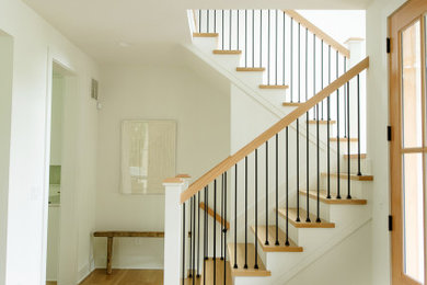 Example of a trendy light wood floor and shiplap wall entryway design in Cincinnati with white walls and a light wood front door