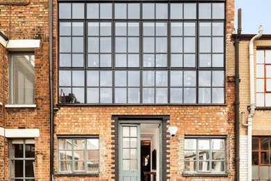 Design ideas for a contemporary two-storey brick exterior in London with a flat roof.