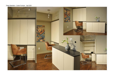 Diseño de despacho actual pequeño con paredes verdes, suelo de madera oscura, escritorio empotrado y suelo marrón