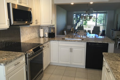 This is an example of a small contemporary u-shaped eat-in kitchen in Tampa with an undermount sink, raised-panel cabinets, white cabinets, granite benchtops, multi-coloured splashback and stainless steel appliances.