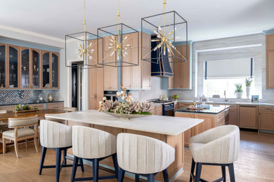 Transitional u-shaped medium tone wood floor and brown floor kitchen photo in Dallas with an undermount sink, recessed-panel cabinets, medium tone wood cabinets, beige backsplash, stone slab backsplash, paneled appliances, two islands and white countertops