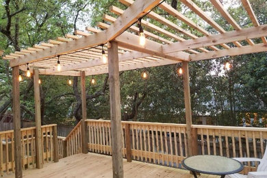 Example of a large backyard deck design in Austin with a pergola