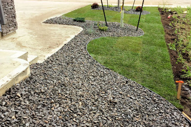 This is an example of a mid-sized modern full sun front yard mulch landscaping in Edmonton.