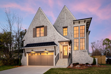 Transitional beige two-story brick house exterior photo in Charlotte with a shingle roof and a brown roof
