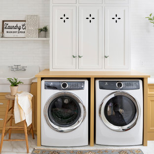 Design ideas for a medium sized country single-wall utility room in Minneapolis with a built-in sink, beaded cabinets, yellow cabinets, a side by side washer and dryer, white floors and yellow worktops.