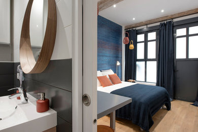 Idée de décoration pour une grande chambre parentale design avec un mur multicolore, parquet clair, aucune cheminée et un sol beige.