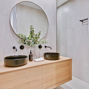 Contemporary bathroom in Sunshine Coast with flat-panel cabinets, light wood cabinets, gray tile, grey walls, a vessel sink, wood benchtops, white floor, a double vanity and a floating vanity.