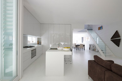 Photo of a contemporary l-shaped open plan kitchen in Sydney with a drop-in sink, flat-panel cabinets, white cabinets, panelled appliances, with island and white floor.