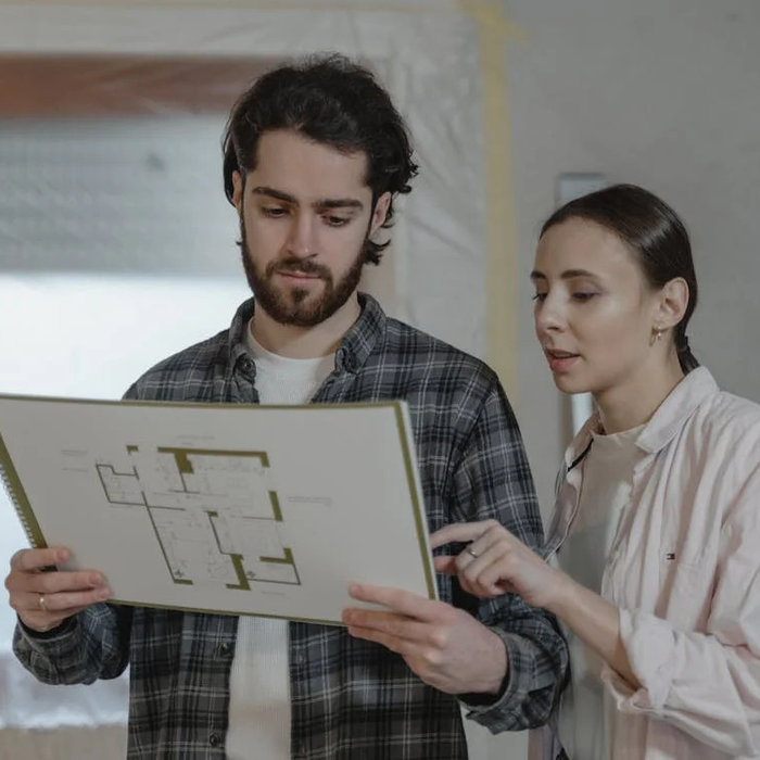 A contractor and homeowner reviewing blueprints together.