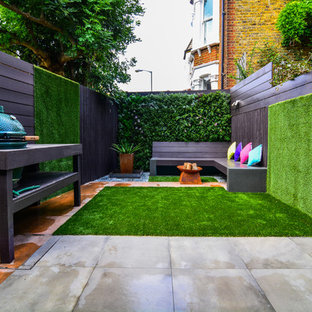 Unbedeckter Moderner Patio hinter dem Haus mit Pflanzwand und Betonplatten in London