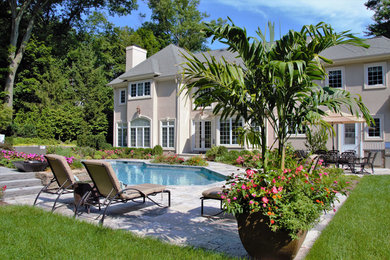 Inspiration for a large contemporary backyard stone and custom-shaped lap hot tub remodel in New York