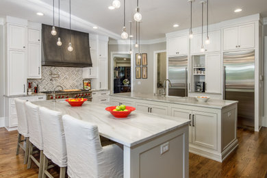 Inspiration for a large u-shaped dark wood floor eat-in kitchen remodel in Atlanta with a farmhouse sink, recessed-panel cabinets, white cabinets, marble countertops, white backsplash, glass tile backsplash, stainless steel appliances and an island