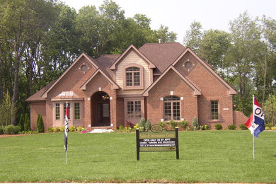 Mid-sized traditional two-storey brick brown exterior in Detroit with a hip roof.