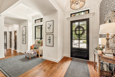 Mid-sized eclectic medium tone wood floor, brown floor, vaulted ceiling and wallpaper entryway photo in Dallas with white walls and a metal front door