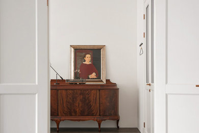 Imagen de habitación de invitados gris y blanca de tamaño medio con paredes blancas, suelo de madera oscura y suelo marrón