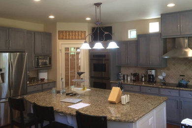Mid-sized trendy l-shaped eat-in kitchen photo in Other with an undermount sink, shaker cabinets, gray cabinets, beige backsplash, stainless steel appliances and an island