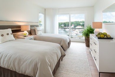 Inspiration for a beach style guest bedroom in Portland Maine with white walls and light hardwood floors.