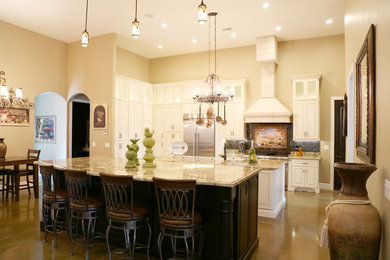 Photo of an expansive mediterranean u-shaped open plan kitchen in Salt Lake City with white cabinets, granite benchtops, stainless steel appliances, multiple islands, a farmhouse sink and raised-panel cabinets.