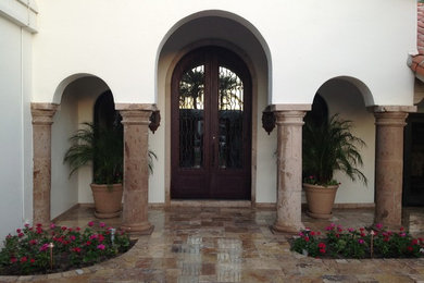 Example of a mid-sized tuscan beige one-story stucco exterior home design in Phoenix with a tile roof