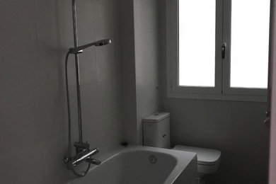 Imagen de cuarto de baño principal minimalista de tamaño medio con sanitario de una pieza, paredes grises, suelo de baldosas de porcelana y suelo marrón