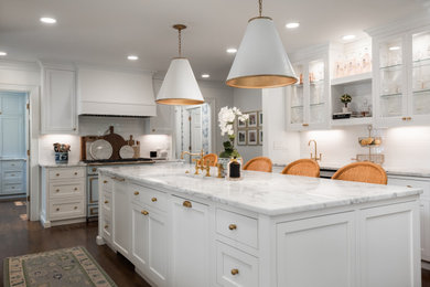 Large elegant u-shaped medium tone wood floor and brown floor open concept kitchen photo in Charlotte with white cabinets, marble countertops, an island, white countertops, an undermount sink, shaker cabinets, white backsplash, ceramic backsplash and paneled appliances