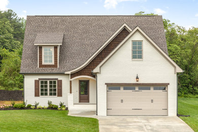 Mid-sized elegant white two-story brick exterior home photo in Other with a shingle roof
