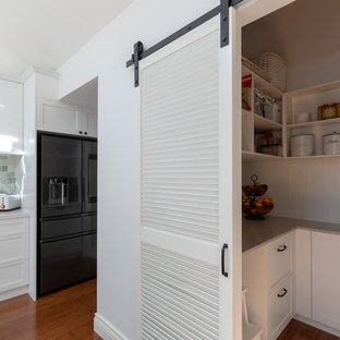 This is an example of an expansive traditional l-shaped kitchen pantry in Canberra - Queanbeyan with shaker cabinets, white cabinets, quartz benchtops, white splashback and beige benchtop.