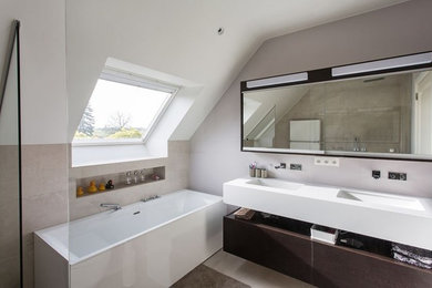 Mid-sized minimalist master black and white tile and stone tile pebble tile floor and brown floor bathroom photo in San Francisco with flat-panel cabinets, dark wood cabinets, a one-piece toilet, white walls, an integrated sink and quartzite countertops