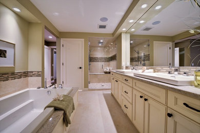 This is an example of a large contemporary master bathroom in Calgary with recessed-panel cabinets, beige cabinets, a drop-in tub, an alcove shower, beige walls, ceramic floors, a drop-in sink, granite benchtops, beige tile, brown tile, porcelain tile, beige floor and a hinged shower door.