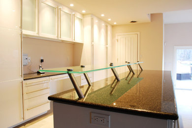 Inspiration for a large contemporary galley limestone floor eat-in kitchen remodel in Philadelphia with an undermount sink, flat-panel cabinets, white cabinets, granite countertops, stainless steel appliances and two islands