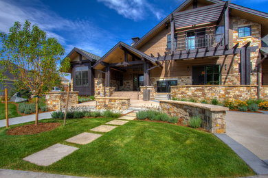 Large modern two-storey brown house exterior in Denver with mixed siding, a gable roof and a shingle roof.