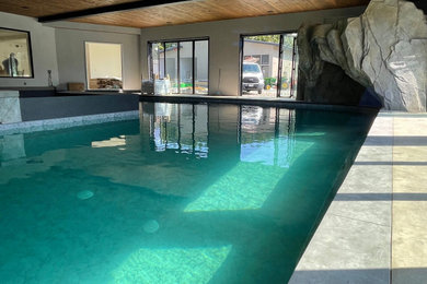 Large minimalist indoor concrete and custom-shaped pool landscaping photo in Vancouver