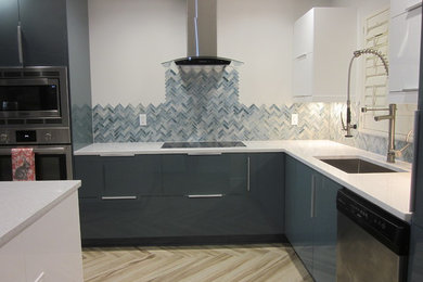Medium sized contemporary open plan kitchen in Other with a submerged sink, flat-panel cabinets, quartz worktops, multi-coloured splashback, glass tiled splashback, stainless steel appliances, porcelain flooring and an island.
