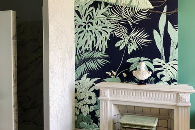 Idée de décoration pour une chambre tradition de taille moyenne avec un mur vert, parquet clair, un poêle à bois, un sol marron et du papier peint.