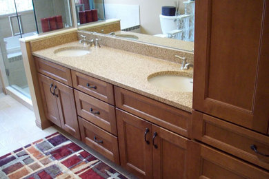 Alcove shower - master ceramic tile alcove shower idea in Cleveland with a drop-in sink, recessed-panel cabinets, medium tone wood cabinets and granite countertops