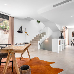 Diseño de despacho mediterráneo, sin chimenea, con paredes blancas, escritorio independiente y suelo beige