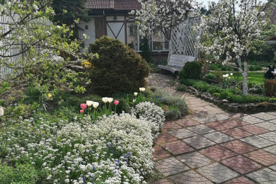 На фото: весенний участок и сад среднего размера на внутреннем дворе в стиле фьюжн с с деревянным забором