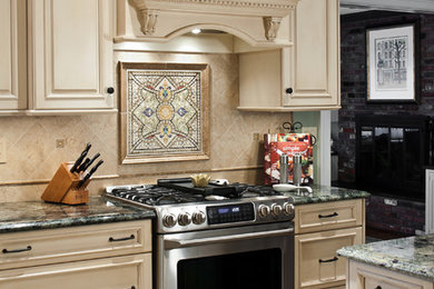 Eat-in kitchen - mid-sized traditional u-shaped ceramic tile eat-in kitchen idea in New York with an undermount sink, beige cabinets, granite countertops, beige backsplash, ceramic backsplash, stainless steel appliances, a peninsula and raised-panel cabinets