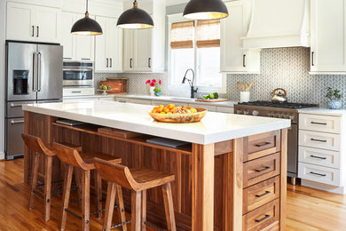 Mid-sized country l-shaped medium tone wood floor and brown floor open concept kitchen photo in DC Metro with an undermount sink, shaker cabinets, white cabinets, quartz countertops, gray backsplash, porcelain backsplash, stainless steel appliances, an island and white countertops