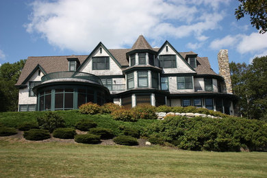 Huge elegant three-story wood exterior home photo in Portland Maine with a shingle roof