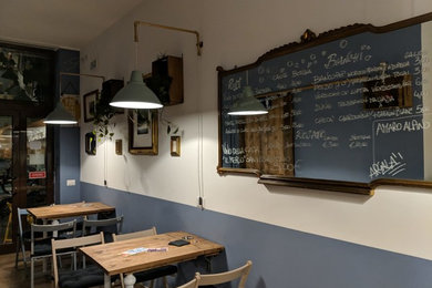 Immagine di una piccola sala da pranzo aperta verso il soggiorno moderna con pareti blu, pavimento in gres porcellanato e pavimento marrone
