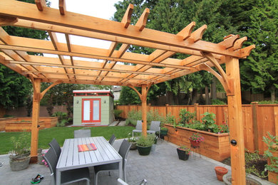 Photo of a large contemporary backyard partial sun garden in Vancouver with concrete pavers.
