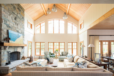 Example of a beach style open concept dark wood floor and brown floor living room design in Toronto with beige walls, a standard fireplace, a stone fireplace and no tv