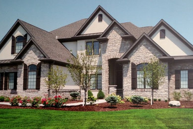 Large mediterranean brown two-story stone gable roof idea in Omaha