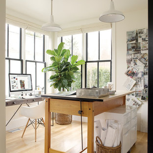 Inspiration for a small modern home studio in Seattle with white walls, light hardwood flooring, no fireplace, a freestanding desk and beige floors.