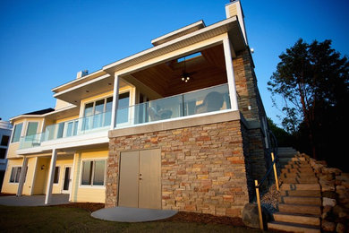 Inspiration for a large contemporary yellow two-story mixed siding exterior home remodel in Other with a hip roof